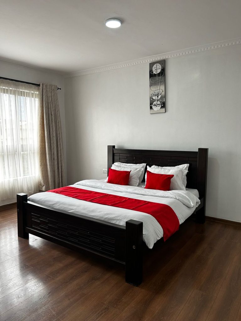 second bedroom with a queen sized bed and large windows for natural light at Serviced and Furnished 3 Bedroom Apartment Nairobi