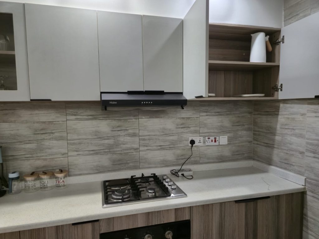 Modern kitchen setup with a cooker and overhead hood – Serviced Furnished Apartment in Westlands Nairobi.