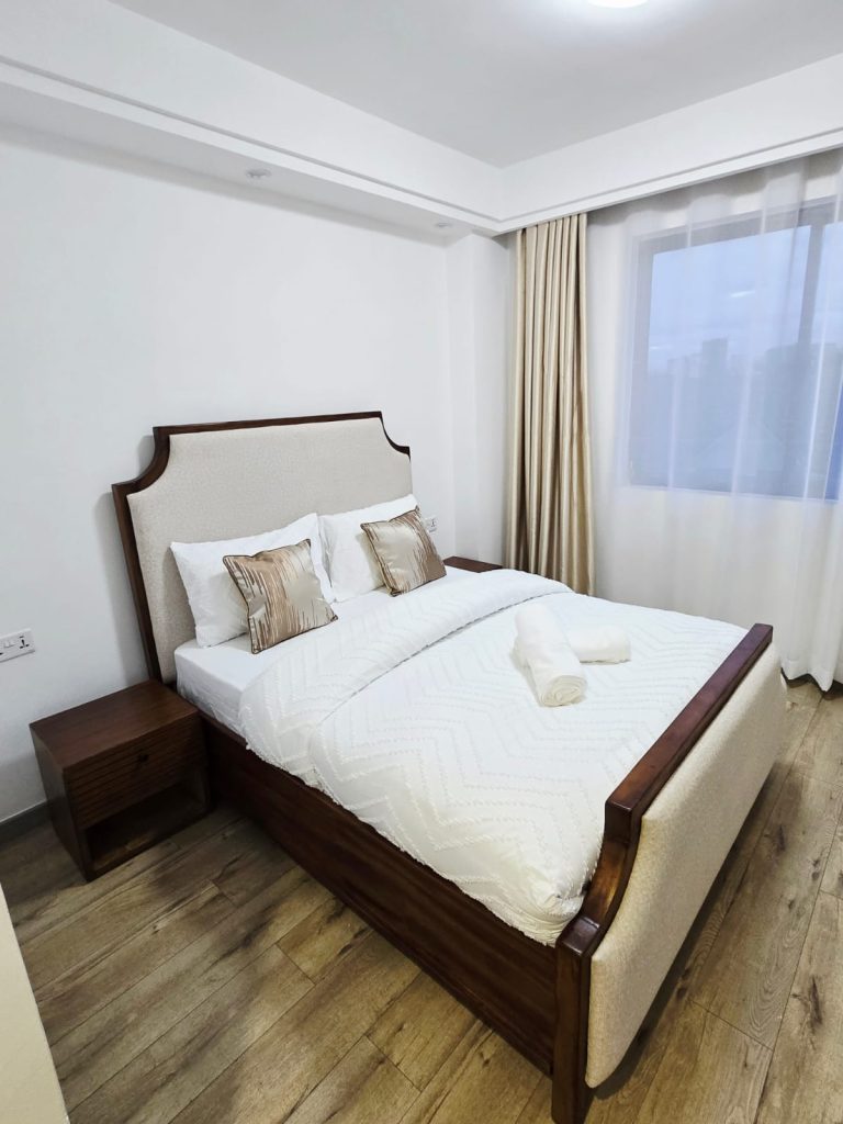 Cozy bedroom with a queen-size bed and natural lighting – Serviced Furnished Apartment in Westlands Nairobi.