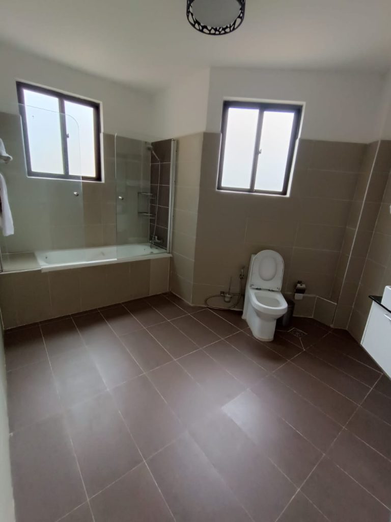 Modern bathroom with a bathtub and toilet in a furnished duplex apartment in Kilimani ideal for short stays