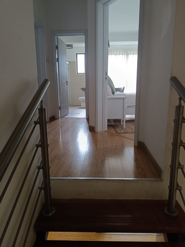 View from staircase showing open bedroom and bathroom layout in a furnished duplex apartment in Kilimani