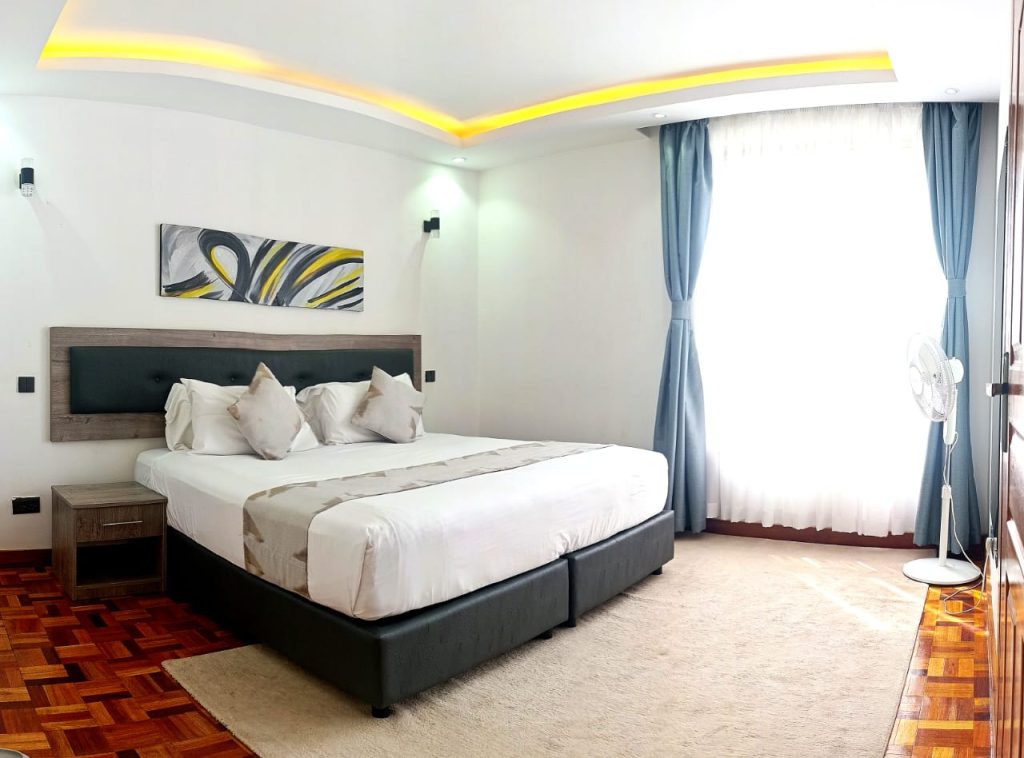 Spacious well lit bedroom with a king size bed at Best Furnished Apartment in Lavington Nairobi