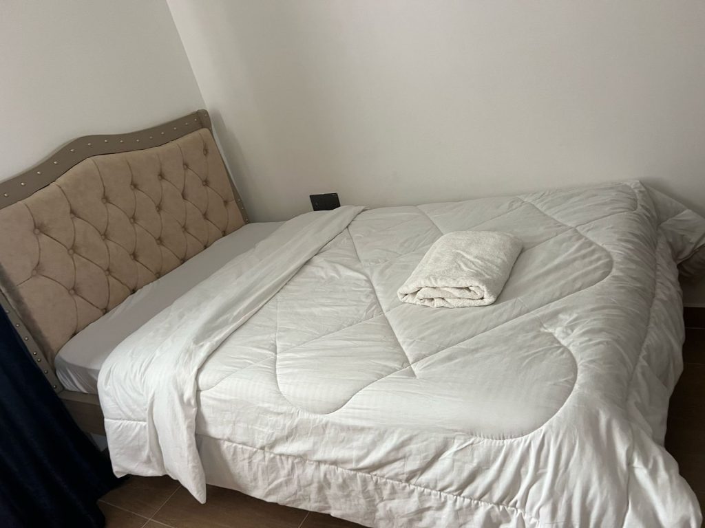 Clean and comfortable second bedroom in Ruaka furnished daily and monthly rental in Nairobi featuring a queen bed with white bedding.