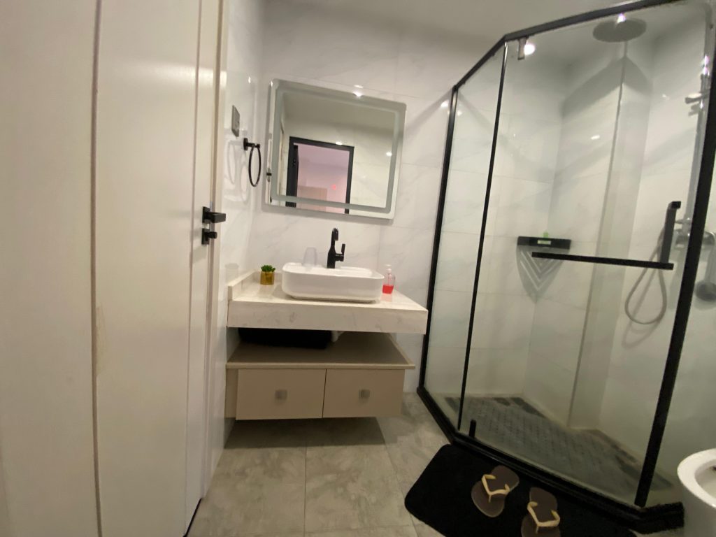 Shared bathroom with cubicle shower and elegant sink in a fully furnished 2 bedroom master ensuite.