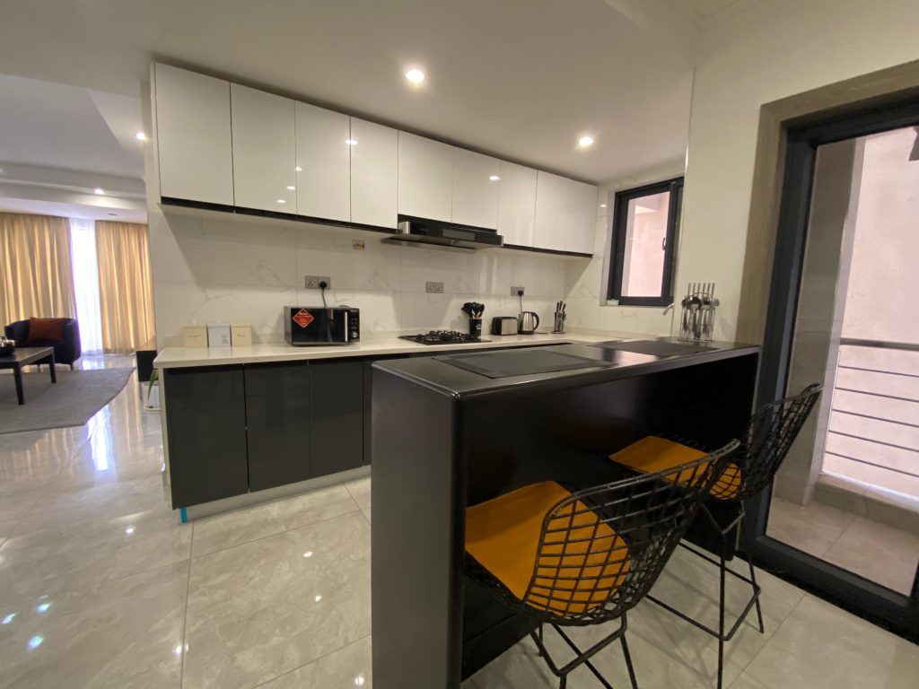 Kitchen with island setting and bar chairs in a fully furnished 2 bedroom master ensuite apartment.
