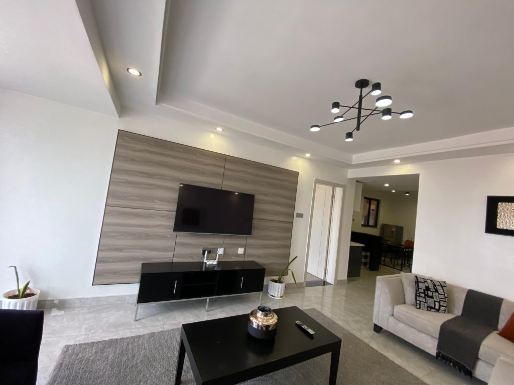 Smart TV mounted on the wall with a stylish coffee table in a modern fully furnished 2 bedroom master ensuite.