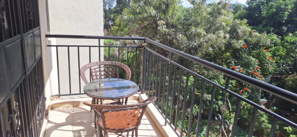 Private balcony with two seats and a medium-sized table for outdoor relaxation – Luxury 3 Bedroom Serviced Apartment in Nairobi