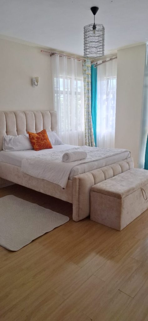 Bedroom with queen size bed and large windows providing ample natural light – Luxury 3 Bedroom Serviced Apartment in Nairobi