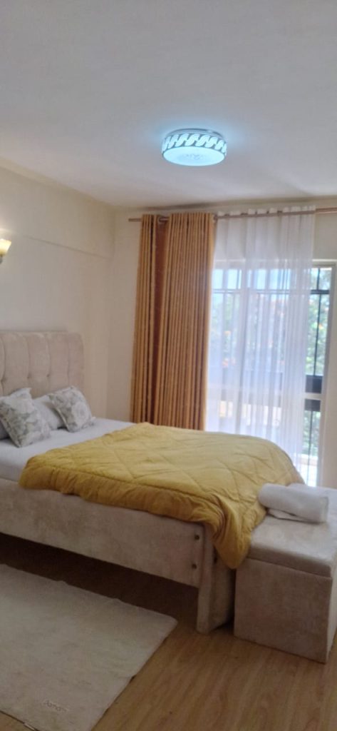 Bright second bedroom featuring white beddings and expansive windows – Luxury 3 Bedroom Serviced Apartment in Nairobi