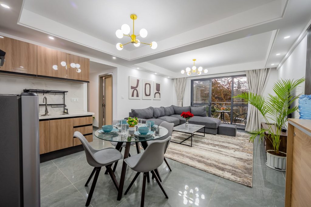 full view of the seating and dining area,large windows and partial parts of open plan kitchen at Sheva suites