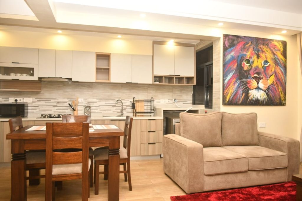 view of the dining area,part of the kitchen and a two seater couch - Executive Furnished Apartment In Kileleshwa Nairobi