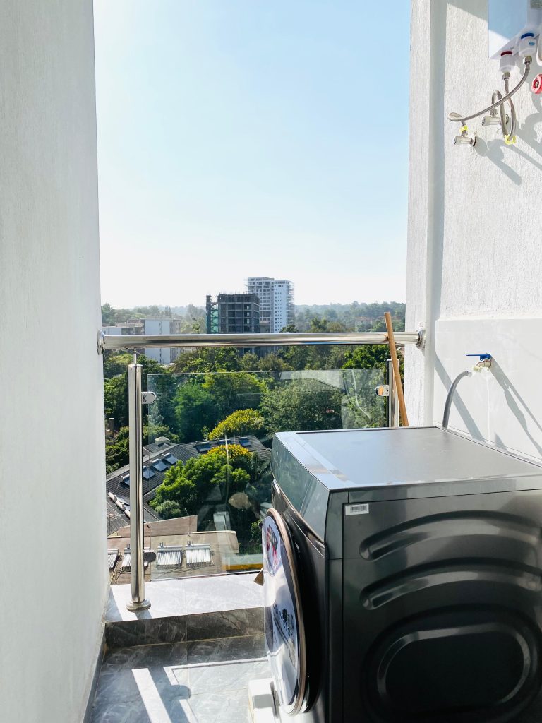 In-unit washing machine included in the affordable 1-bedroom furnished apartment in Nairobi.