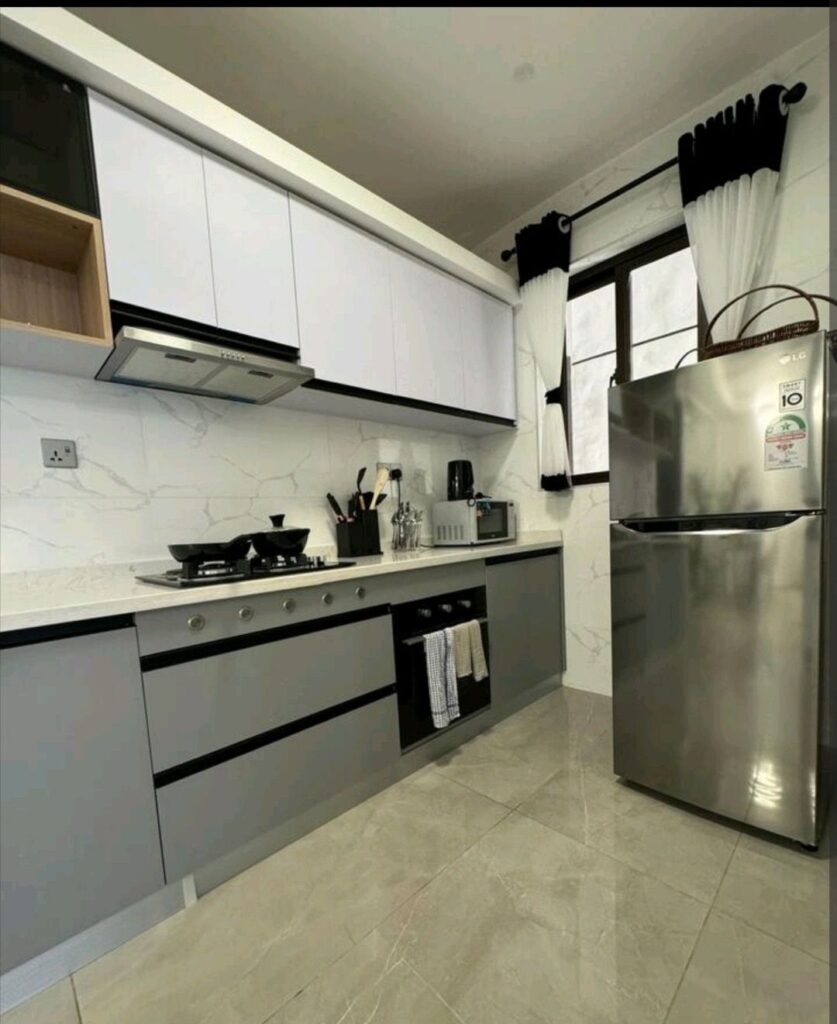 fitted open plan kitchen at 108 Furnished apartment with a fridege,microwave,electric kettle, utencils, and cooker with hood