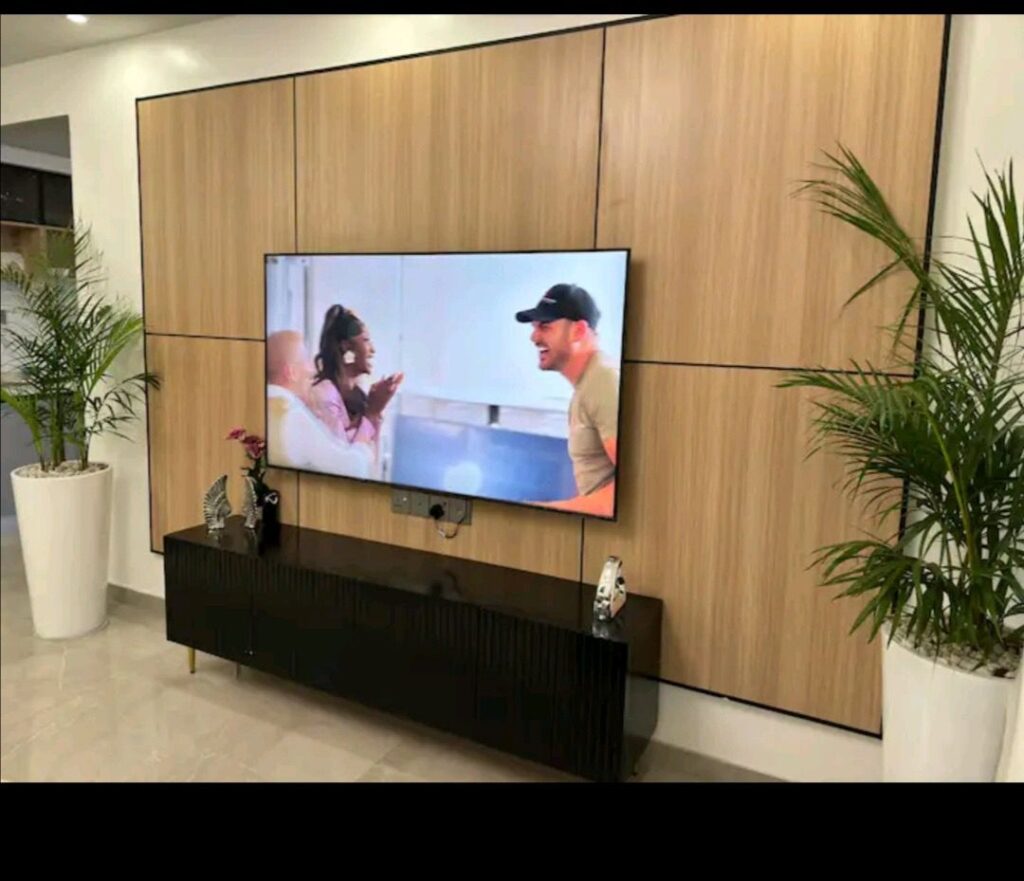 A mounted smart Tv with a console under it at 108 Furnished apartment