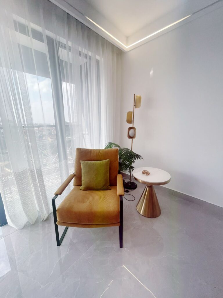 an accent chair in the bedroom of a 2 bedroom furnished apartment near juction mall