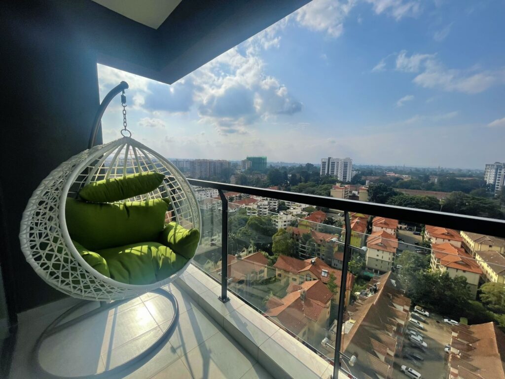 a swinging chair in the balcony with secnic views at the 2 bedroom furnished apartment near juction mall