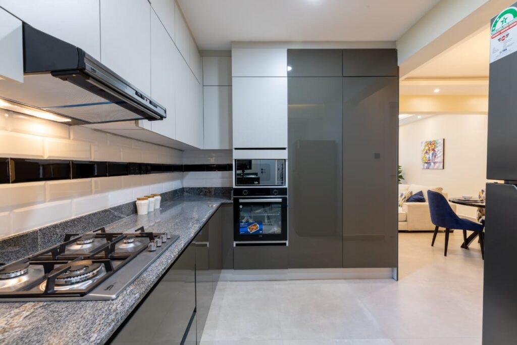 Kitchen with fitted cabinets, a cooker and a hood at the 3 bedroom apartment along General Mathenge Gardens