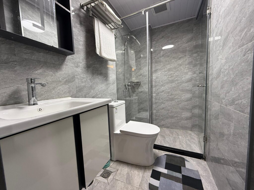 Bathroom with cubicle glass shower ,a toilet and a sink with a mirror at Furnished Apartment at Alina Harbour Kilimani