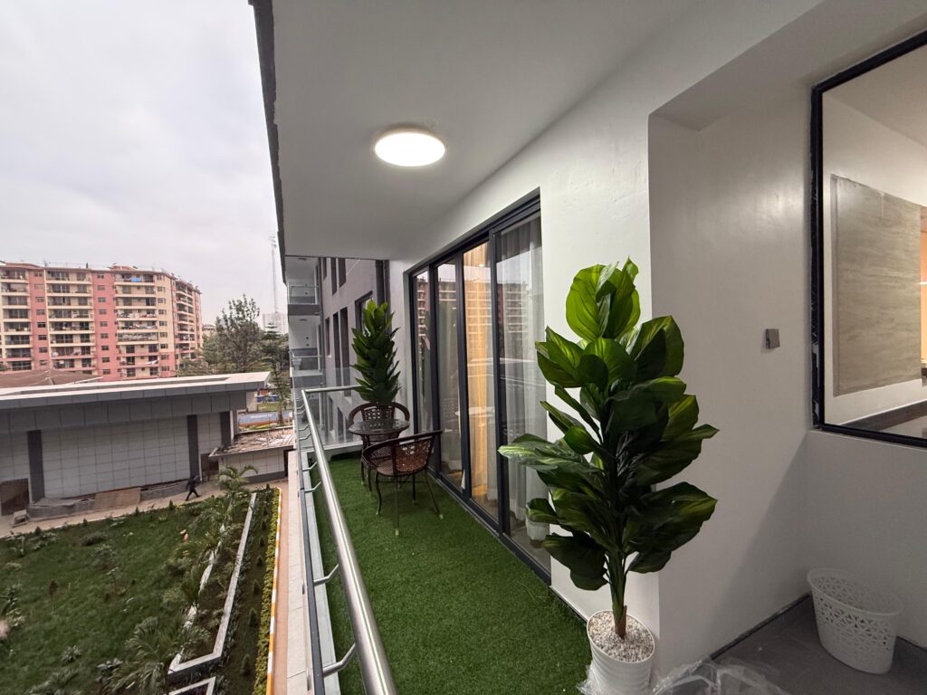 an Expansive balcony with two seats a medium table at Furnished Apartment at Alina Harbour Kilimani