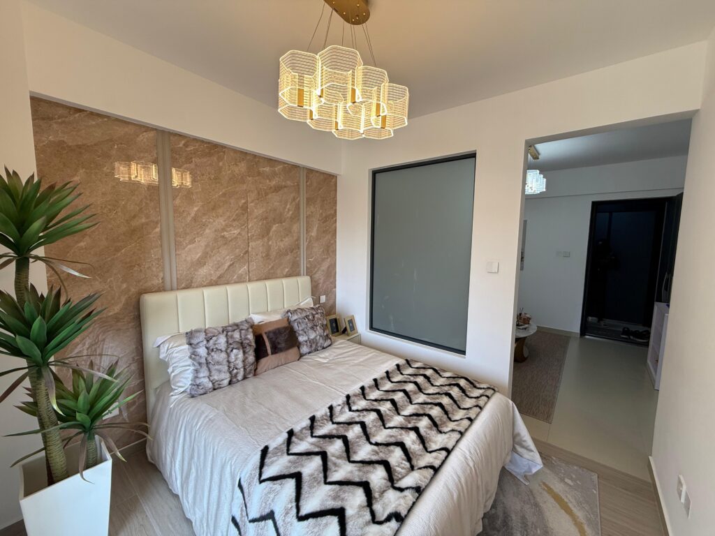 bedroom well lit with chandalier and natural lighting from the large windows at One Bedroom Apartment on Gataka Road