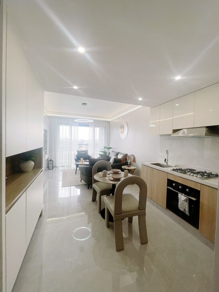 a fitted open plan kitchen with fitted cabinets and appliances and a dining table for two at Furnished apartment on riara road