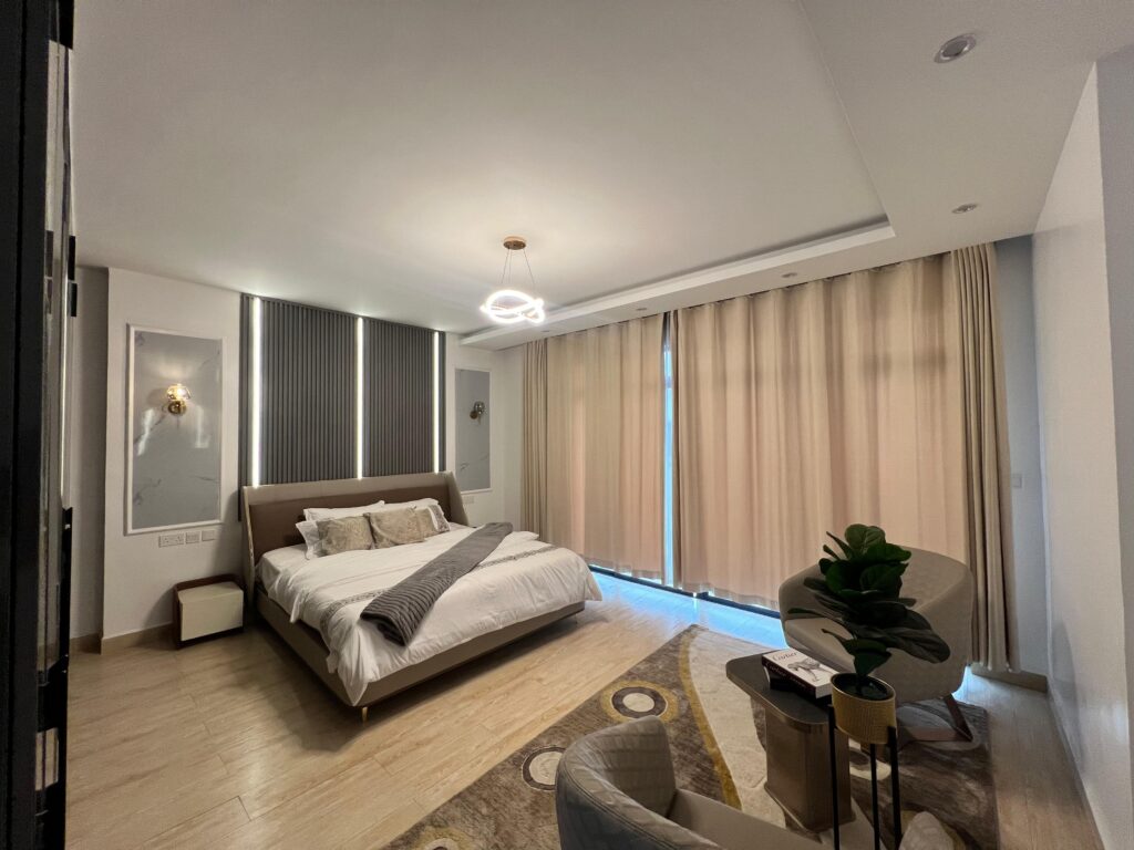 bedroom with large windows covered by a curtain inside Isra Residency Parklands