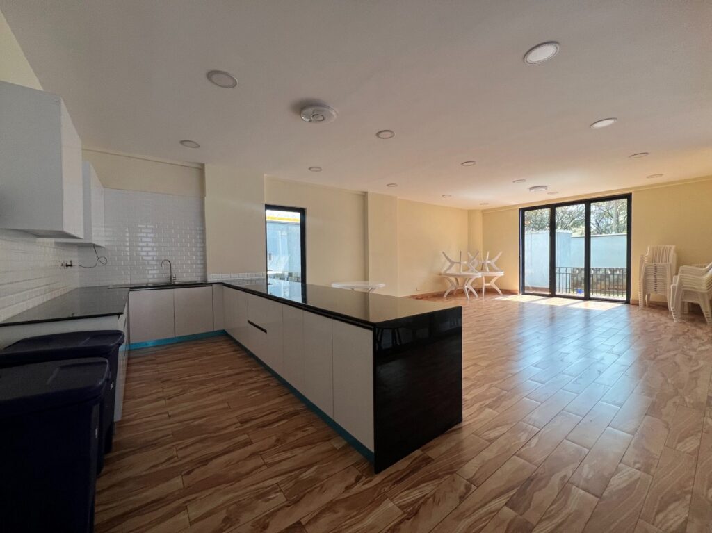 An expansive open plan kitchen fitted with cabinets at Silver Decks Apartment