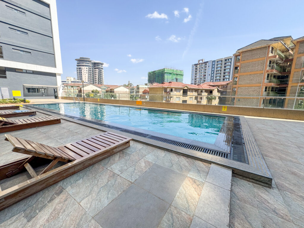 a clean swimming pool and sun loungers at furnished apartment at southpark apartment