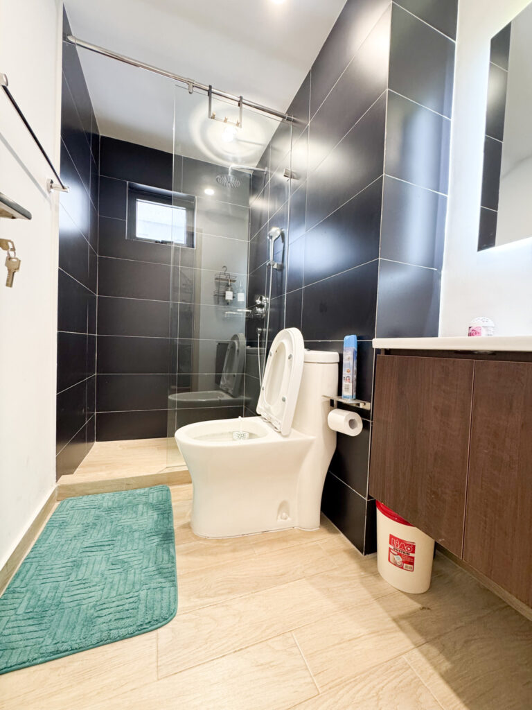 A shower, a toilet and a sink in a bathroom inside furnished apartment at southpark apartment