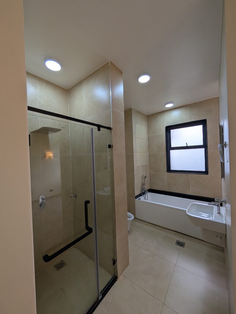 bathroom with a bathtub ,glass shower and a toilet at the unfurnished 2 bedroom apartment