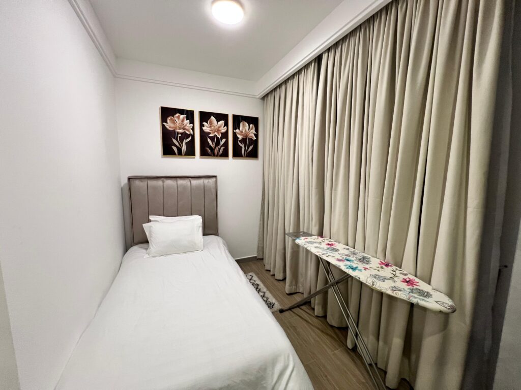 the 3rd bedroom with an ironing board at the Furnished apartment at winchester Gardens