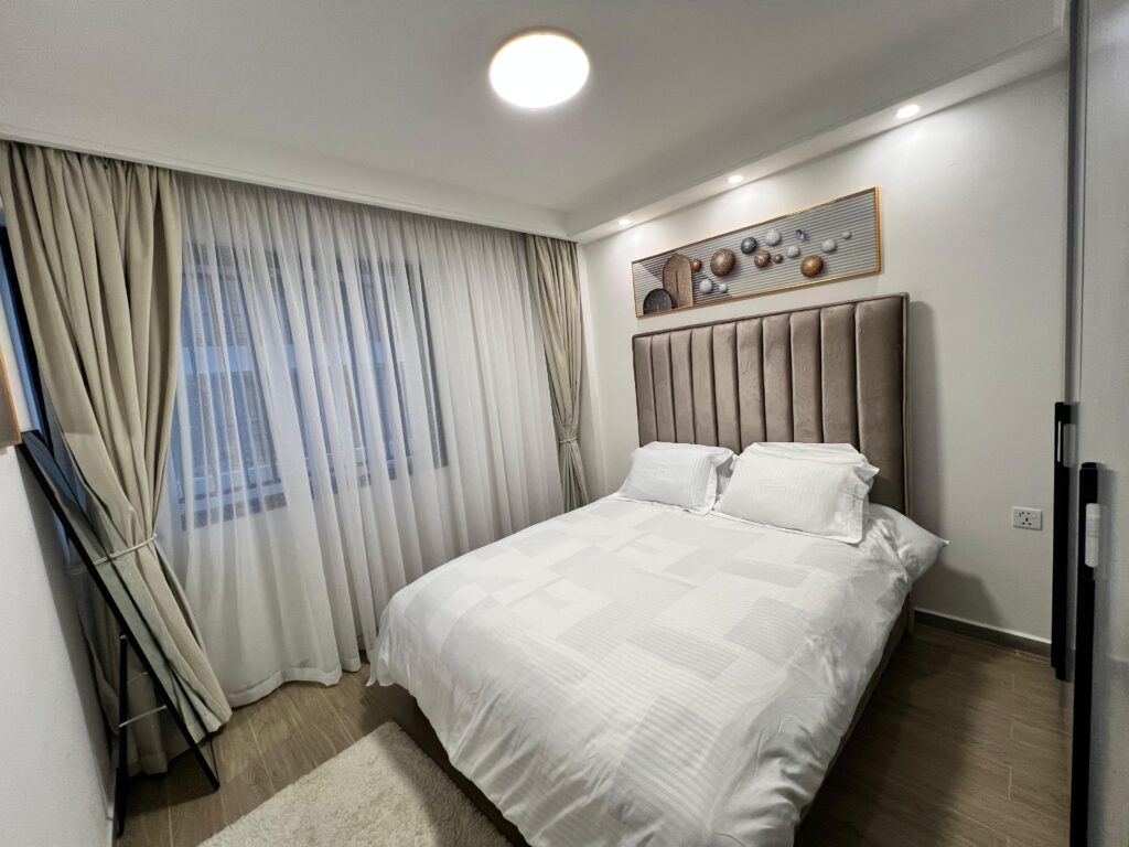 bedroom with large windows with curtains at Furnished apartment at winchester Gardens