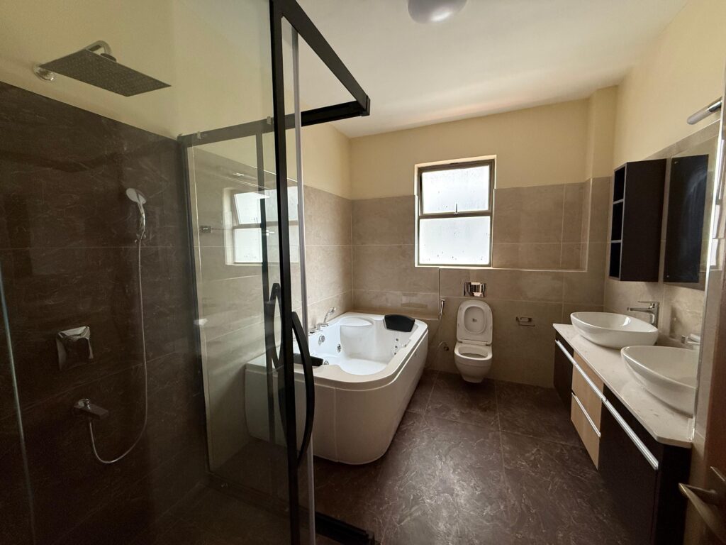 a bathroom with cubicke shower, toilet and a bathtub at the 3 bedroom Apartment On General Mathenge Road