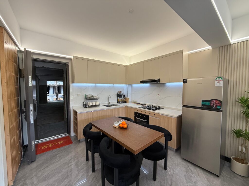 The dining area with open plan kitchen in the background at the Two Bedroom Apartment on Wood Avenue
